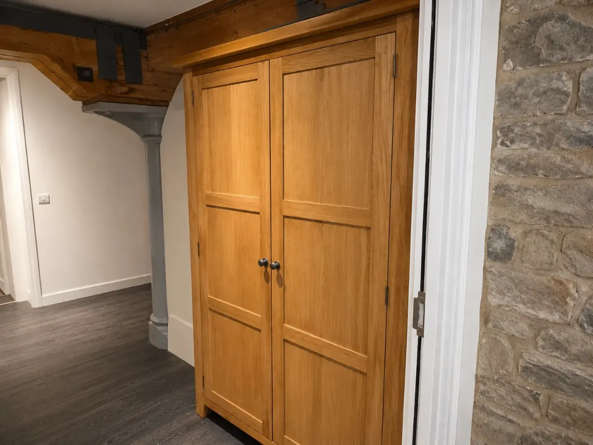Bespoke oak storage cabinet installation with shaker-style doors in Cobham, Surrey